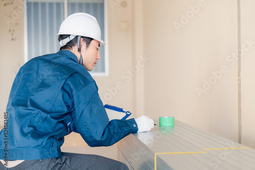 Foto 建設現場で資材の確認をする大工