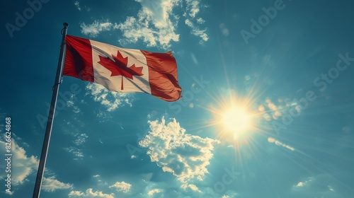 A Canadian flag is flying in the sky on a sunny day photo