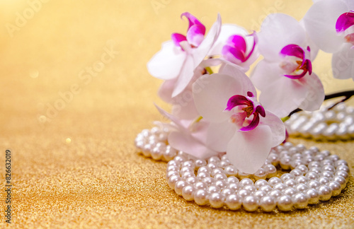 A branch of white orchids on a shiny gold background

