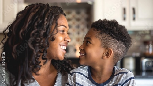 Happy mother and son smiling at each other in the kitchen
