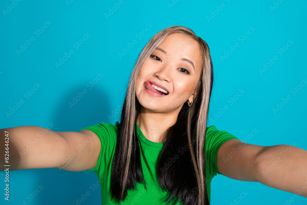 Portrait of nice young girl make selfie tongue lick lips wear t-shirt isolated on turquoise color background Portrait of nice young girl make selfie tongue lick lips wear t-shirt isolated on turquoise color background
