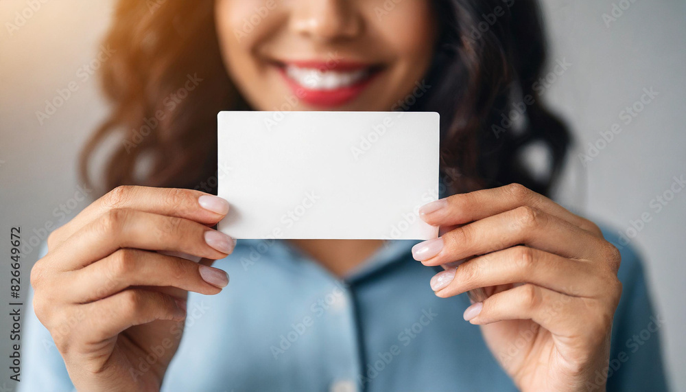 Female hands hold blank paper card, symbolizing message, promotion, or business advertisement Female hands hold blank paper card, symbolizing message, promotion, or business advertisement