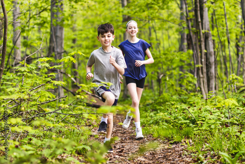 brother and sister jogging in green park on a sunny summer evening.