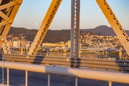 a lua perto do pôr-do-sol e a estrutura da  ponte Hercílio Luz emoldurando parte da cidade de  Florianópolis, Santa Catarina, Brasil Florianopolis photo