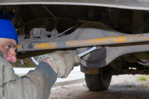 A mechanic is servicing the rear axle of a car.