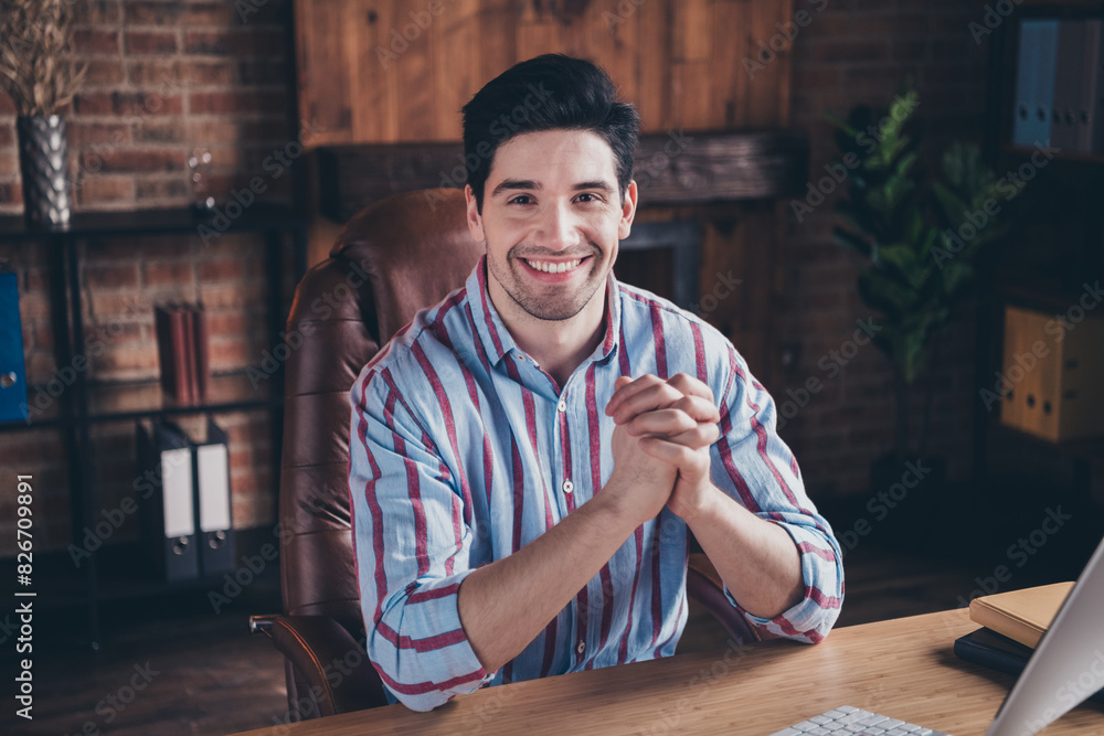 Photo of nice young corporate man sit chair desktop wear striped shirt loft interior office indoors Photo of nice young corporate man sit chair desktop wear striped shirt loft interior office indoors