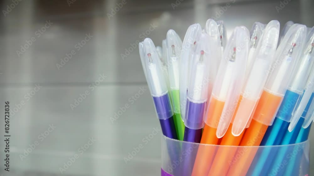 Close-up of many new pens in a plastic box and a man's hand taking one Close-up of many new pens in a plastic box and a man's hand taking one