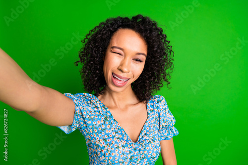 Photo of nice young woman make selfie eye wink wear top isolated on green color background © deagreez