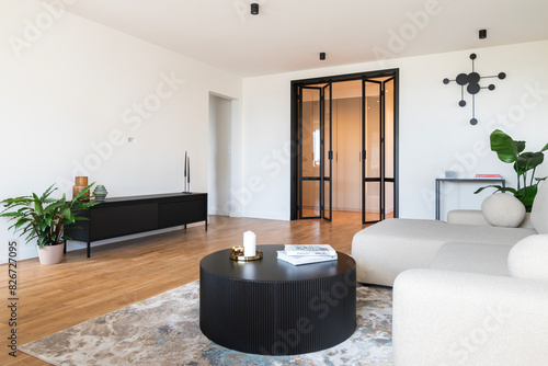 contemporary living room with minimalist decor, featuring neutral colors, modern furniture, and a touch of greenery