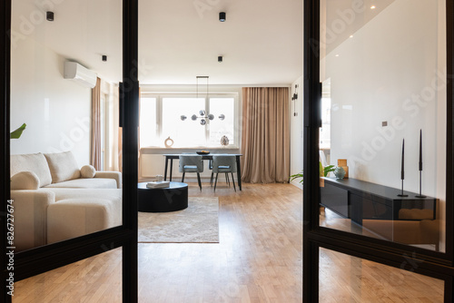 contemporary living room with minimalist decor, featuring neutral colors, modern furniture, and a touch of greenery