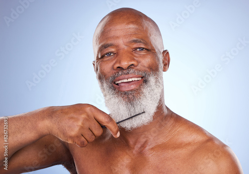 Portrait, beard care and senior black man with comb isolated on blue background for grooming. Beauty, style and hygiene with treatment or cosmetics in studio with confidence, clear skin and wellness.