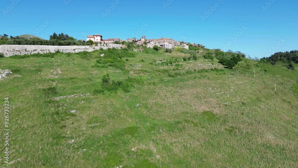 approaching flight drone view of panoramic old town of Casertavecchia from bottom of green hill in a clear morning light approaching flight drone view of panoramic old town of Casertavecchia from bottom of green hill in a clear morning light
