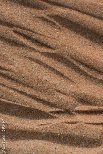 Lines drawn in brown sand background, beautiful sand texture, overhead view of chocolate brown sand, zen pattern drawn in the sand, Top view of fine grain texture © this_baker