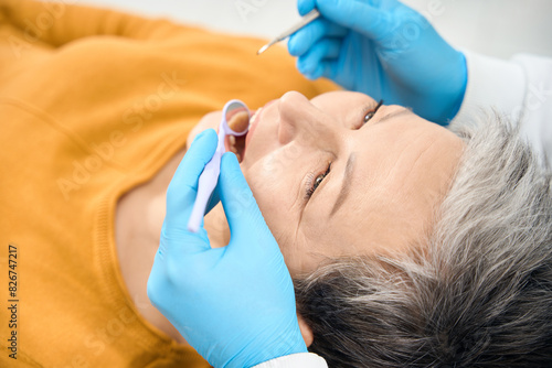 Dental hygienist undertaking patient examination using special dental tools