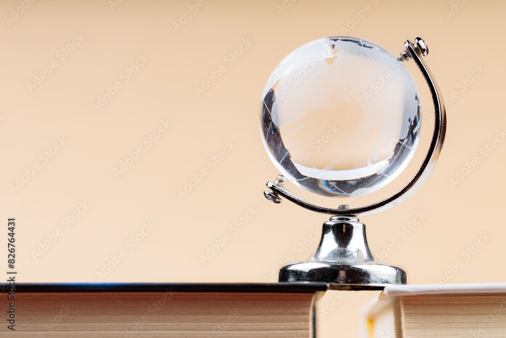 Glass Globe on Stack of Books, Fragile Balance of Earth's Ecosystem Concept, Copy Space Glass Globe on Stack of Books, Fragile Balance of Earth's Ecosystem Concept, Copy Space
