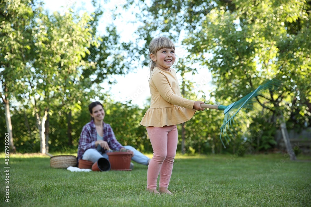 Fototapeta premium Mother and her daughter working together in garden