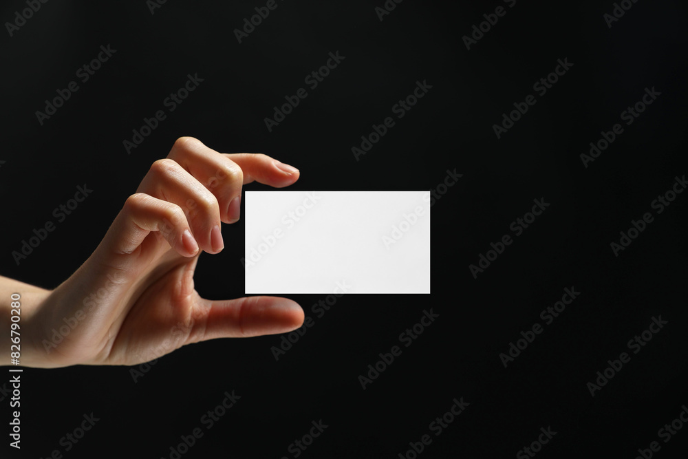 Woman with blank business card on black background, closeup. Mockup for design Woman with blank business card on black background, closeup. Mockup for design