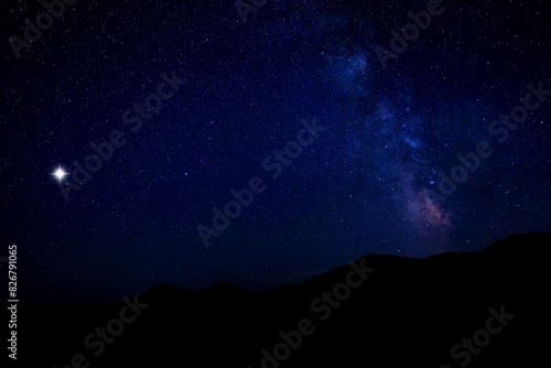 Sky with twinkling stars over mountains at night