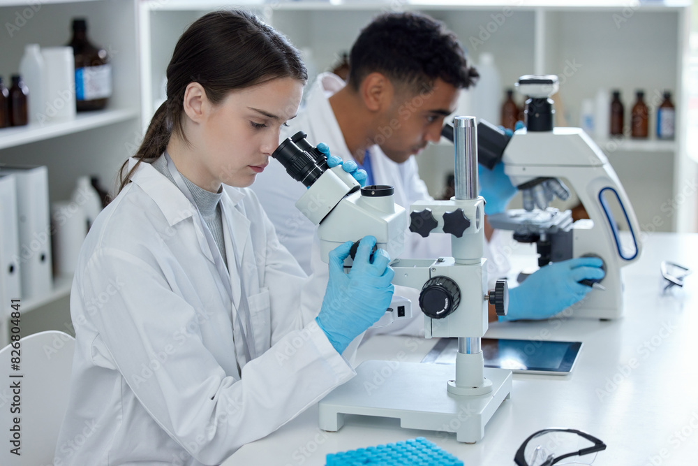 Science, man and woman with microscope, teamwork and medical research in laboratory. Vaccine innovation, scientist and lab technician with collaboration, medicine and pharmaceutical development study Science, man and woman with microscope, teamwork and medical research in laboratory. Vaccine innovation, scientist and lab technician with collaboration, medicine and pharmaceutical development study