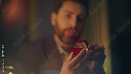 Handsome man making proposal to woman at night date closeup. Macho opening box photo