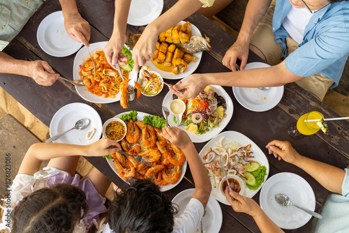 Photography Happy Asian Multi-Generation family enjoy and fun spending time together having lunch eating seafood at beach restaurant during travel nature ocean at tropical island on summer holiday vacation