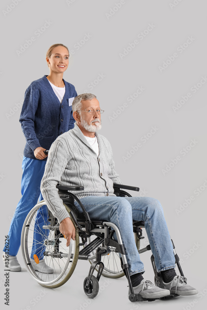 Senior man in wheelchair with nurse on light background Senior man in wheelchair with nurse on light background