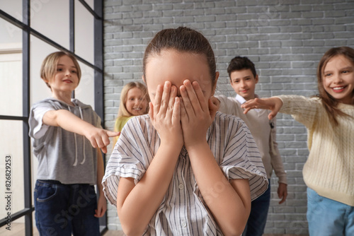 Bullied little girl crying at school, closeup
