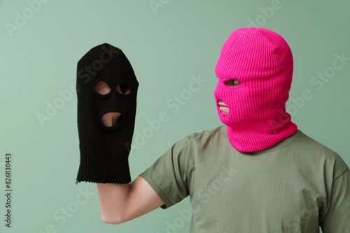 Handsome young man with balaclavas on green background © Pixel-Shot