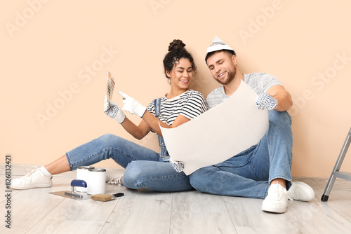 Obraz na plátně Beautiful young couple with color palette near beige wall doing repair in new ho