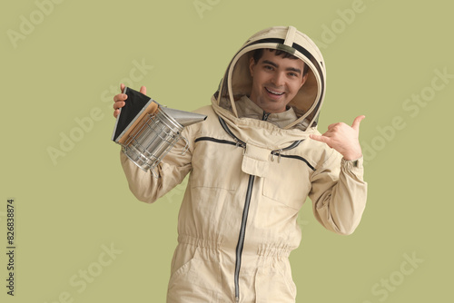 Male beekeeper with smoker ...