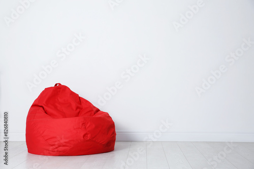 Red bean bag chair near white wall in room photo