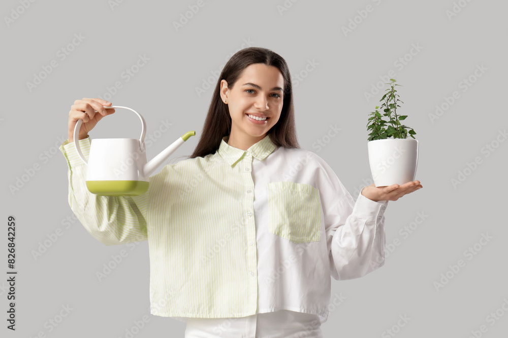 Young happy woman with watering can and houseplant on white background Young happy woman with watering can and houseplant on white background