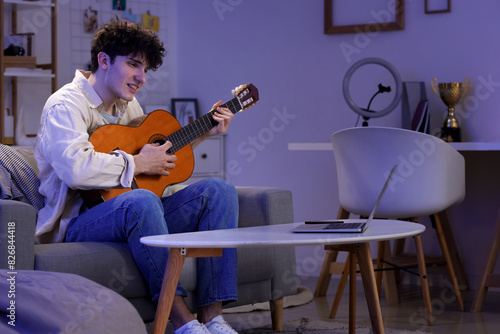 Male student playing guitar...