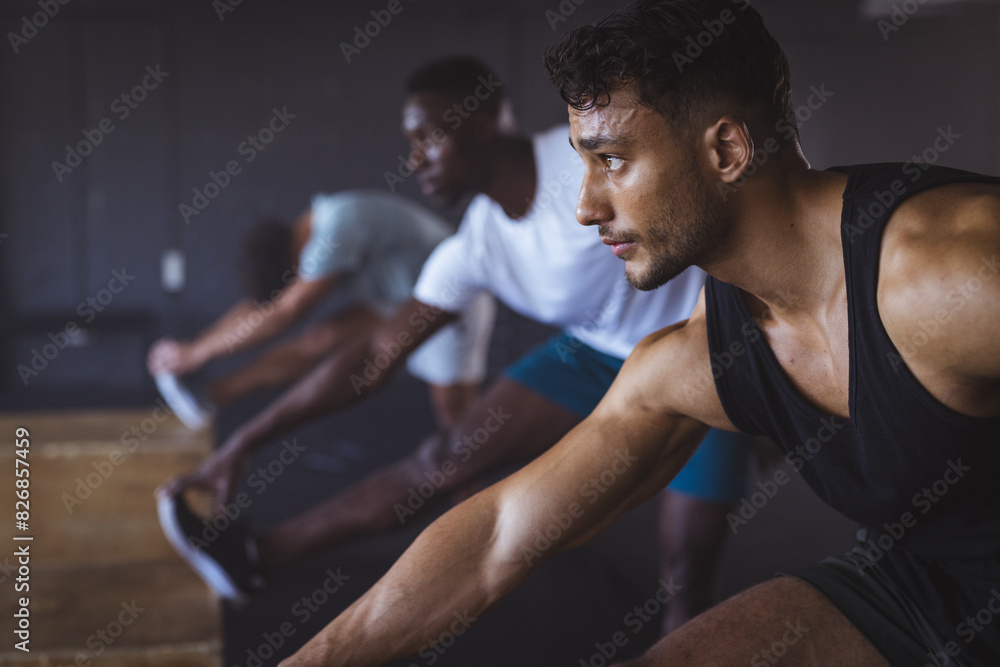 At gym, fit biracial man stretching with a group of diverse men, copy space At gym, fit biracial man stretching with a group of diverse men, copy space