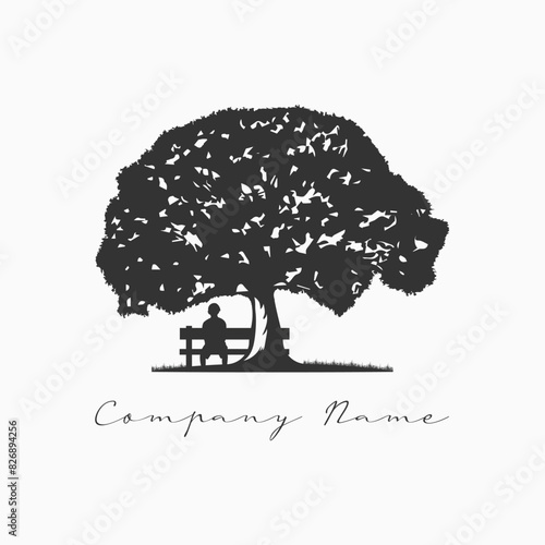Silhouette of a man sitting on a bench under a tree