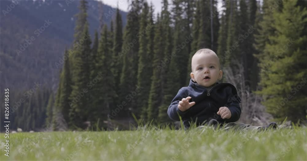 Baby boy playing outside on green grass in lush Canadian Nature. British Columbia, Canada. Slow Motion, Cinematic. Baby boy playing outside on green grass in lush Canadian Nature. British Columbia, Canada. Slow Motion, Cinematic.