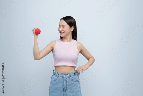 Woman lifting dumbbell in oversized jeans unwearable