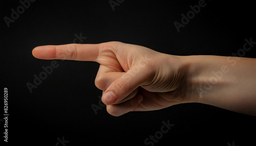 a man hand with the index finger pointing outward, in black background, direction, instruction, and emphasis. © LADALIDI
