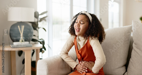 Schilderij op canvas Young girl, stomach ache or allergies on couch in home for health problem or digestion recovery on weekend