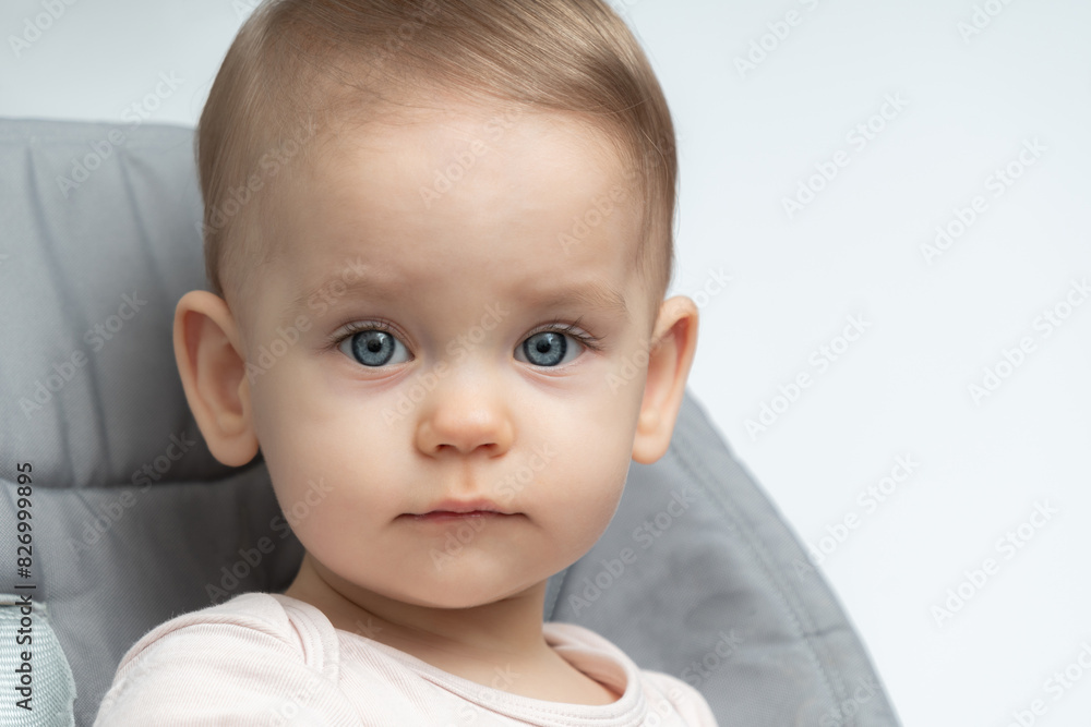 Close-up of a toddler baby gazing at the camera with calm face