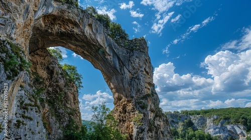 The grandeur of nature on full display as a natural archway stands tall against a bright blue sky.