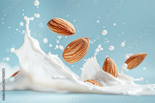 Whole foure almonds in milk splash isolated on blue background. Nuts in organic vegan liquid. photo