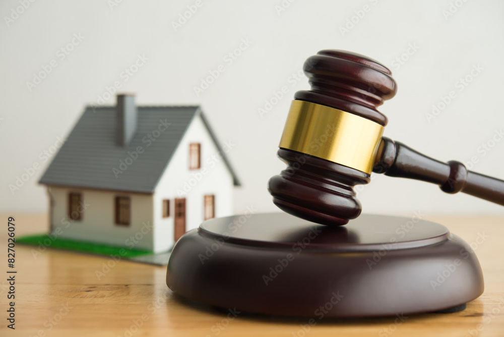 House model, hammer judge gavel on wooden table with white wall background. Foreclosure, bankruptcy concept. Person is unable to reply outstanding debts or obligations, stops mortgage payment. House model, hammer judge gavel on wooden table with white wall background. Foreclosure, bankruptcy concept. Person is unable to reply outstanding debts or obligations, stops mortgage payment.