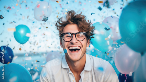 man wearing eyeglasses and laughing around confetti © Neha