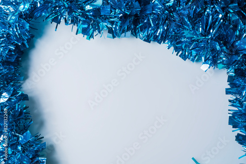 Blue tinsel on a white background with copy space for text.