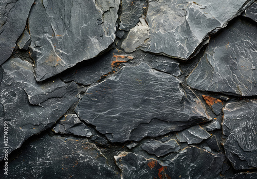 A closeup of the rugged texture and beauty of black basalt rock, with its dark gray color and intricate patterns. The background is a blurred landscape. Created with Ai