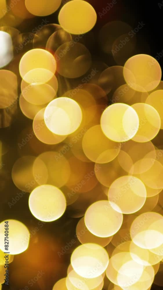 Movement of blurred Christmas lights. Yellow bokeh on a dark background. Vertical video. Movement of blurred Christmas lights. Yellow bokeh on a dark background. Vertical video.