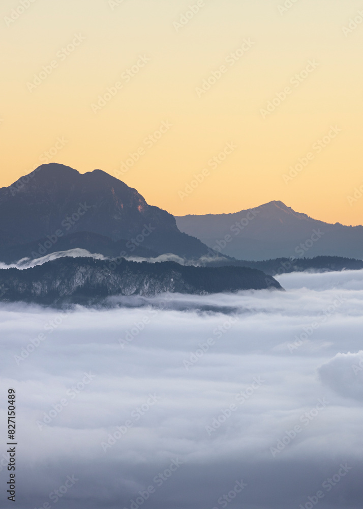 Sunrise illuminating mountains above a soft sea of clouds Sunrise illuminating mountains above a soft sea of clouds