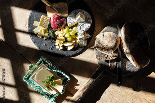 Cheese platter with bread and butter in rustic sunlight photo