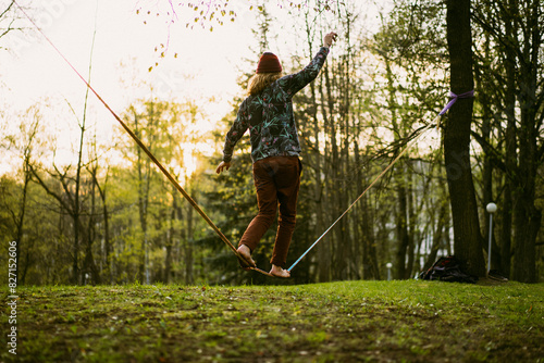 Athletic man trains on a slackline.